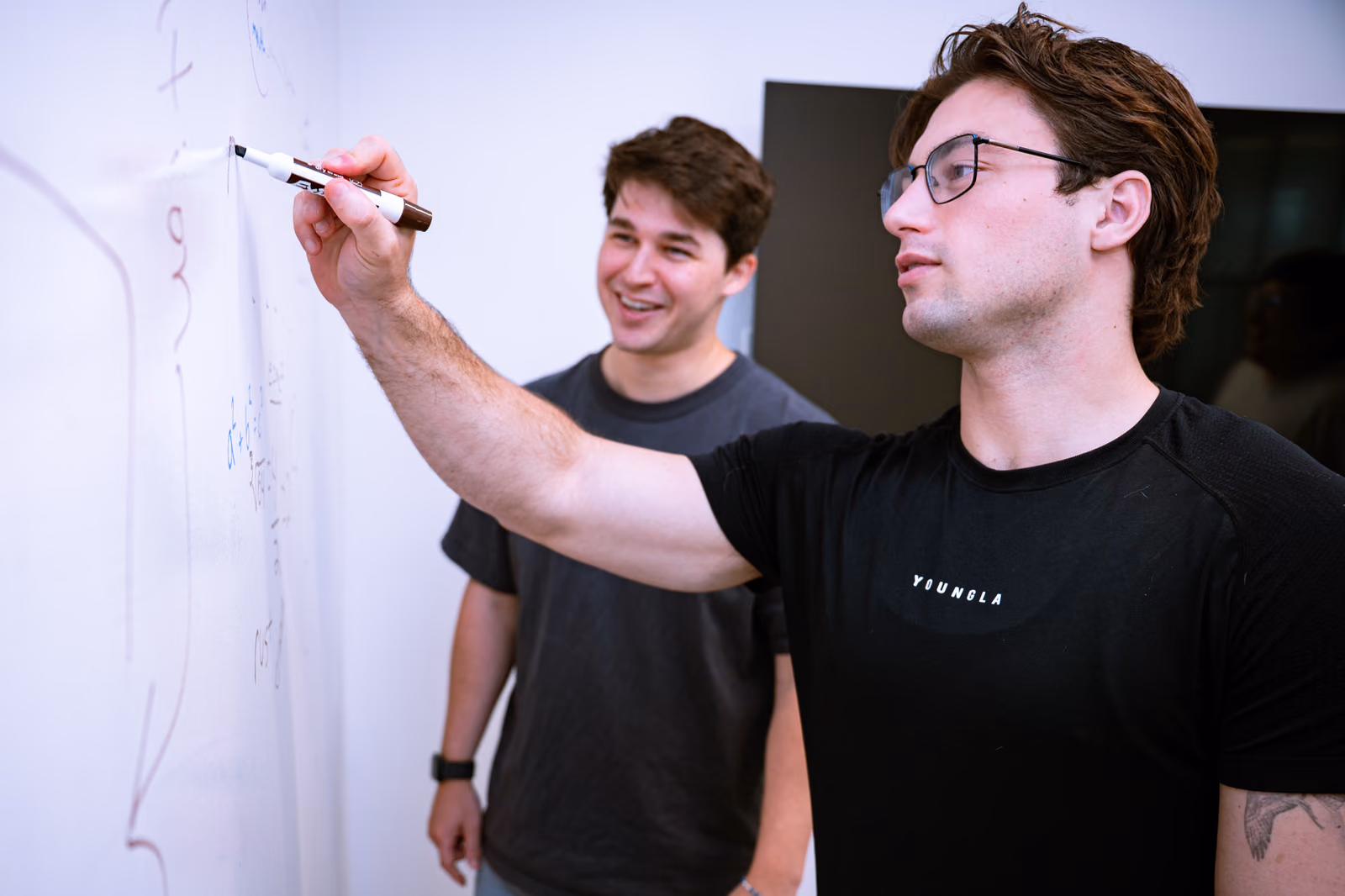 GovDash teammates working through a problem at a whiteboard